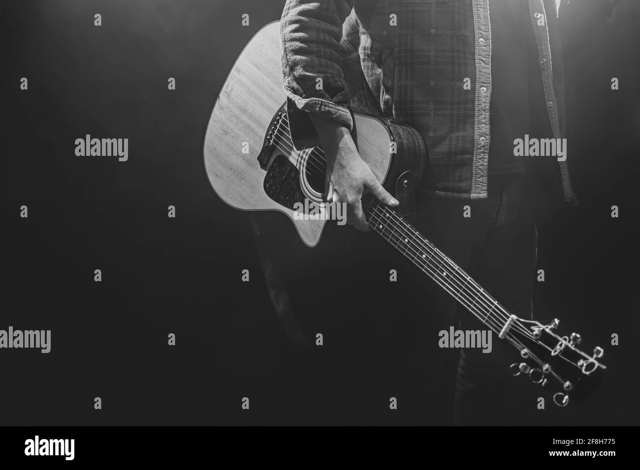 Un homme tenant une guitare acoustique dans ses mains copier l'espace. Banque D'Images