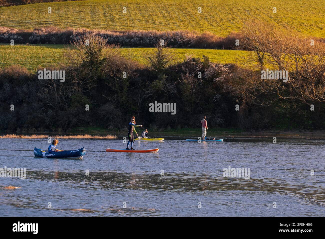 Les gens pagayent sur la rivière Gannel dans des kayaks et sur des pagayboards Stand Up à Newquay, en Cornouailles. Banque D'Images