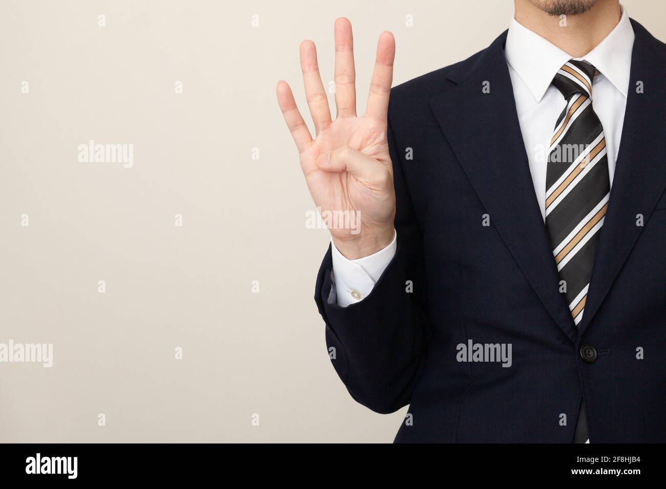 Un homme en costume avec quatre doigts Banque D'Images