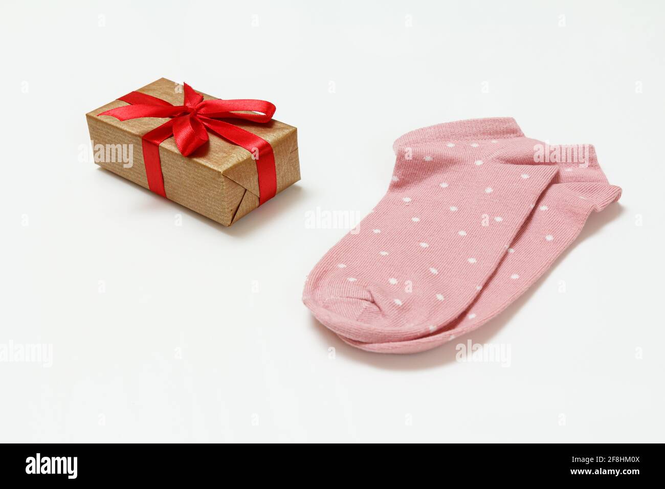 Paire de chaussettes roses pour femmes et boîte cadeau sur fond blanc, vue du dessus. Banque D'Images