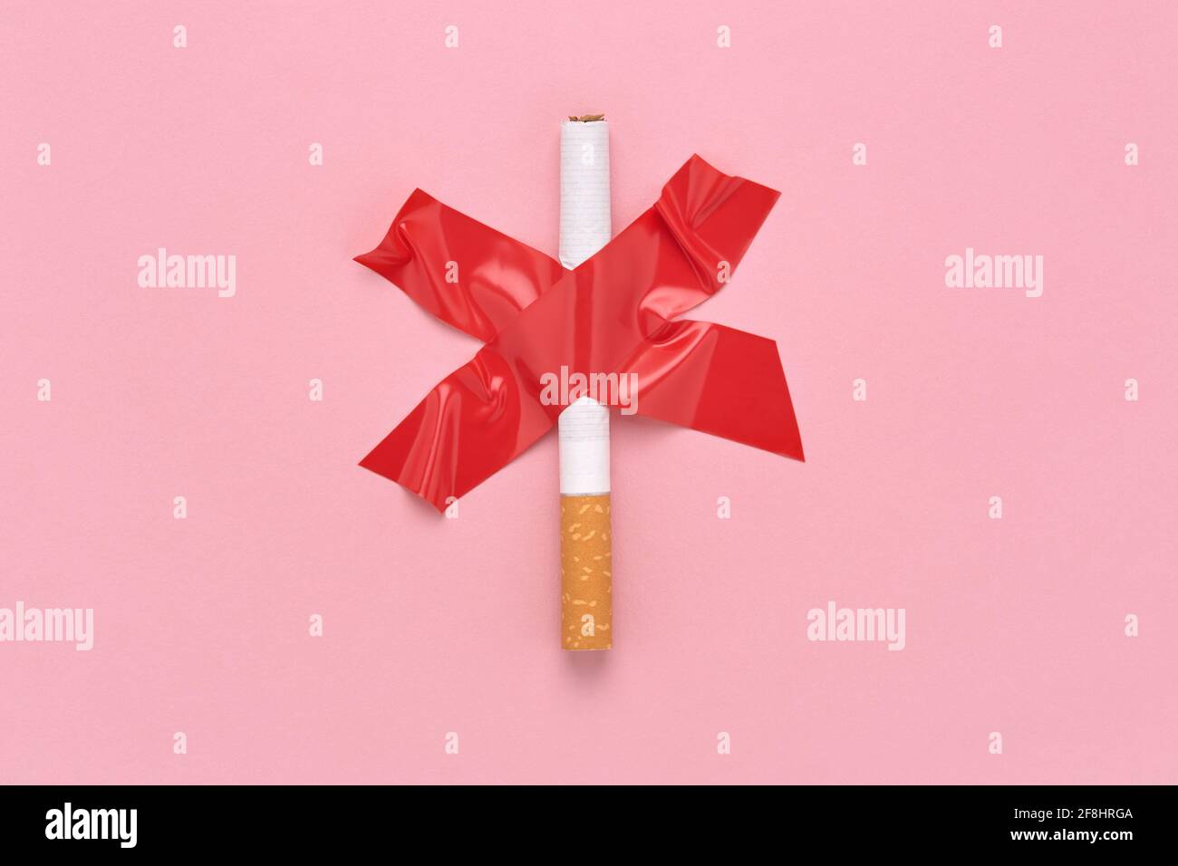 Une croix a collé une cigarette, symbole interdiction de fumer, ruban rouge. Banque D'Images