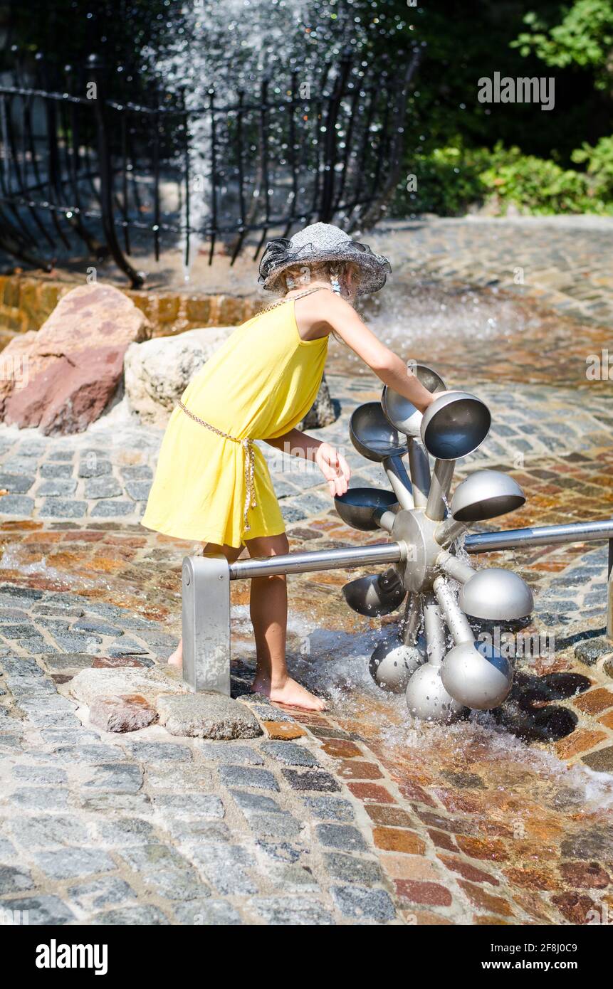 petite fille blonde jouant avec l'attraction aquatique Banque D'Images