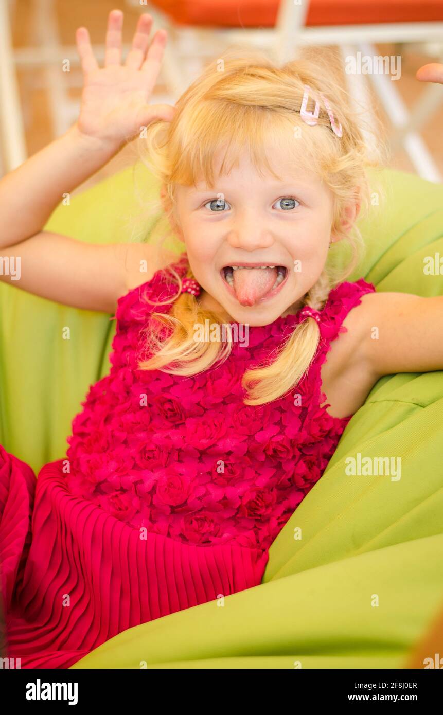 adorable petite fille blonde faisant des visages drôles Banque D'Images