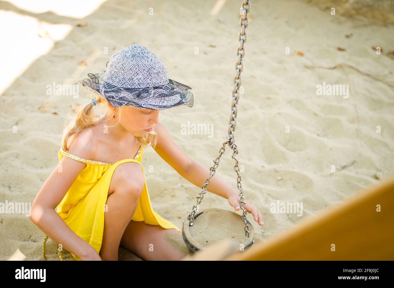 petite fille blonde jouant dans un bac à sable sur l'aire de jeux Banque D'Images