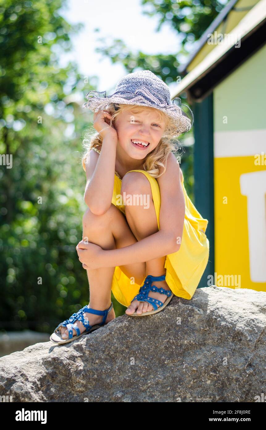 petite fille blonde en robe jaune jouant sur l'aire de jeux Banque D'Images