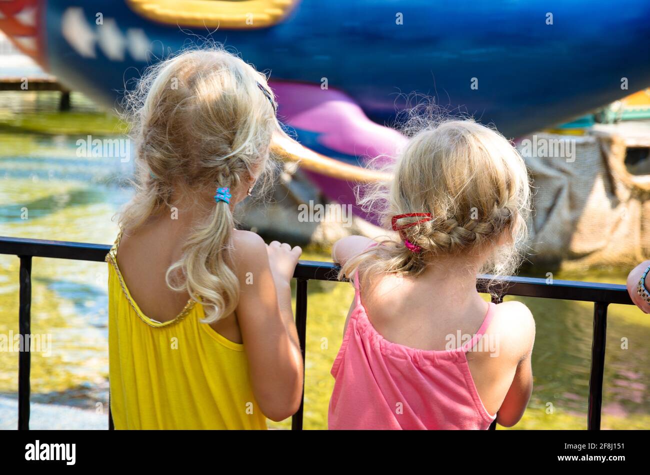 deux filles blondes regardant quelque chose de vue de dos Banque D'Images