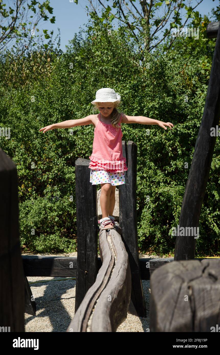 petite fille en équilibre dans rail en bois Banque D'Images