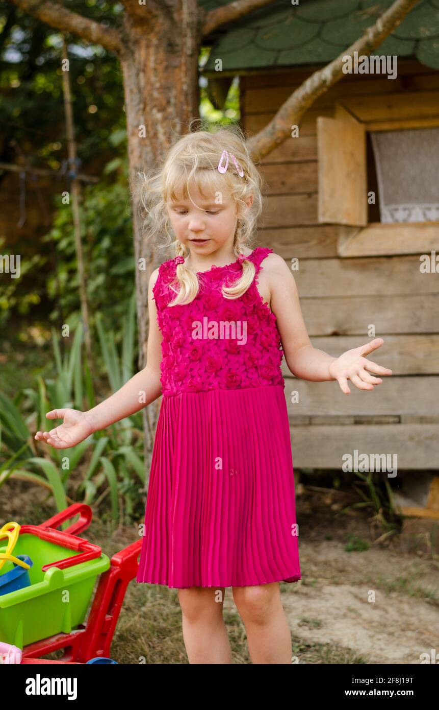 petite fille blonde en robe rose Banque D'Images