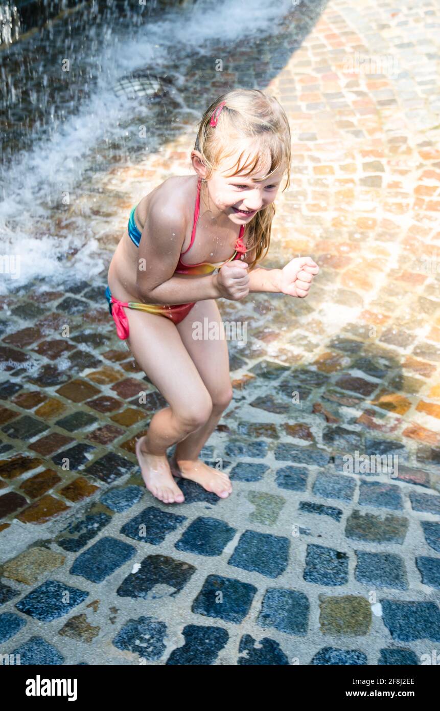 petite fille blonde jouant avec de l'eau Banque D'Images