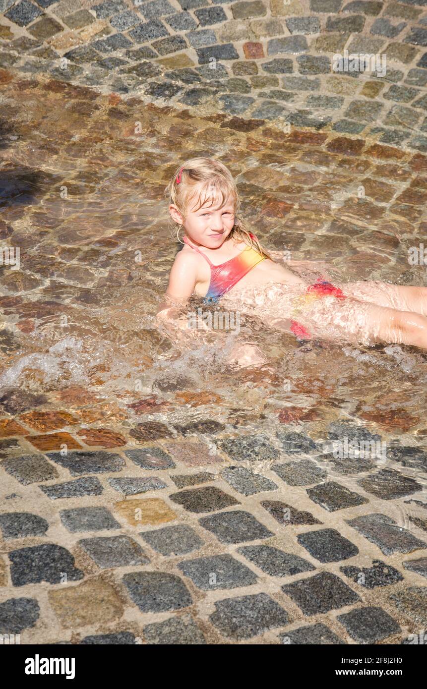 petite fille blonde jouant dans l'eau Banque D'Images