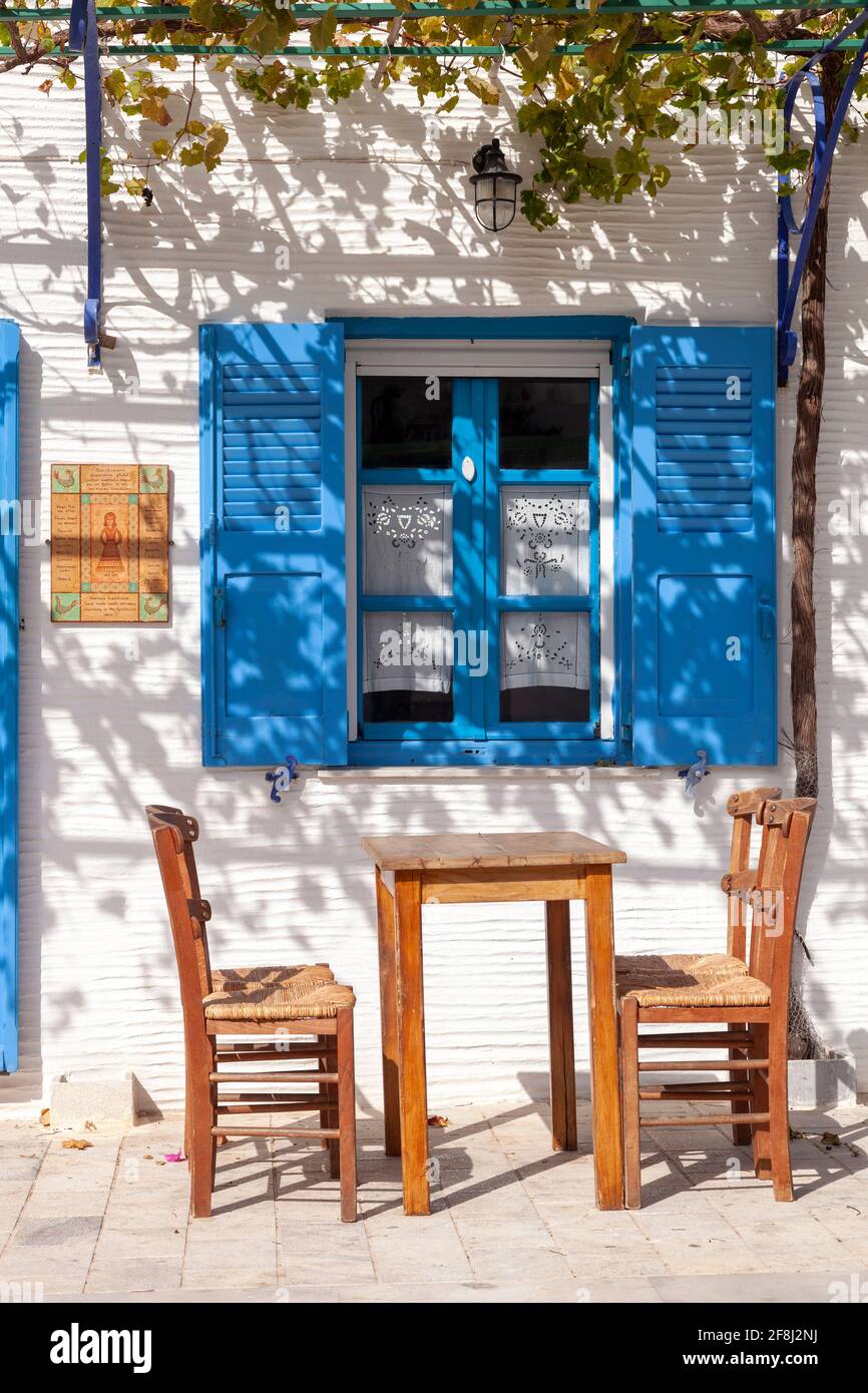 Kafenio traditionnel (café-restaurant) dans l'île grecque de Paros, dans le village de Lefkes, avec ses murs blanchis à la chaux et ses chaises et table traditionnelles en bois Banque D'Images