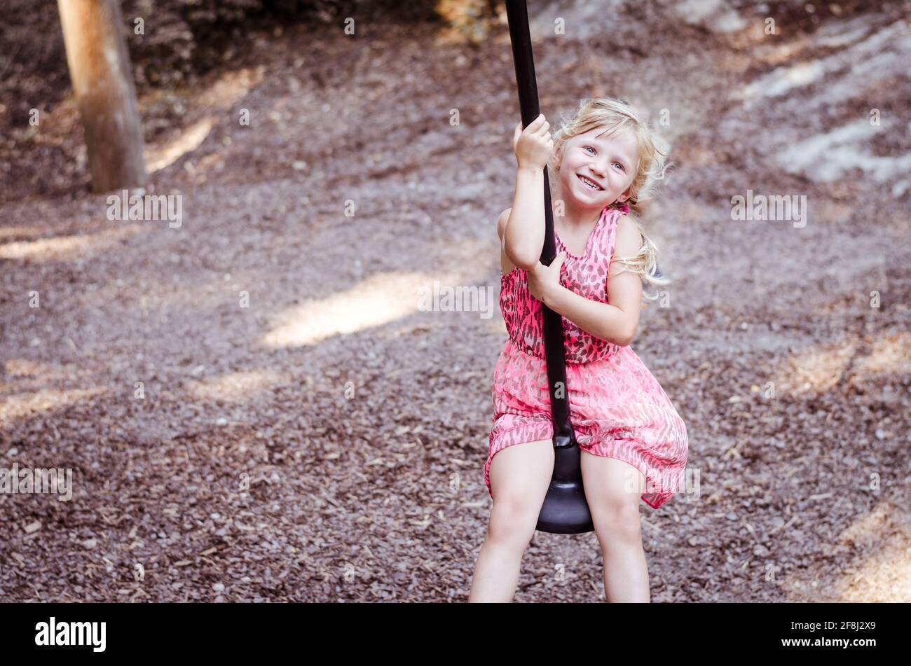petite fille blonde jouant dans l'aire de jeux de sthe Banque D'Images