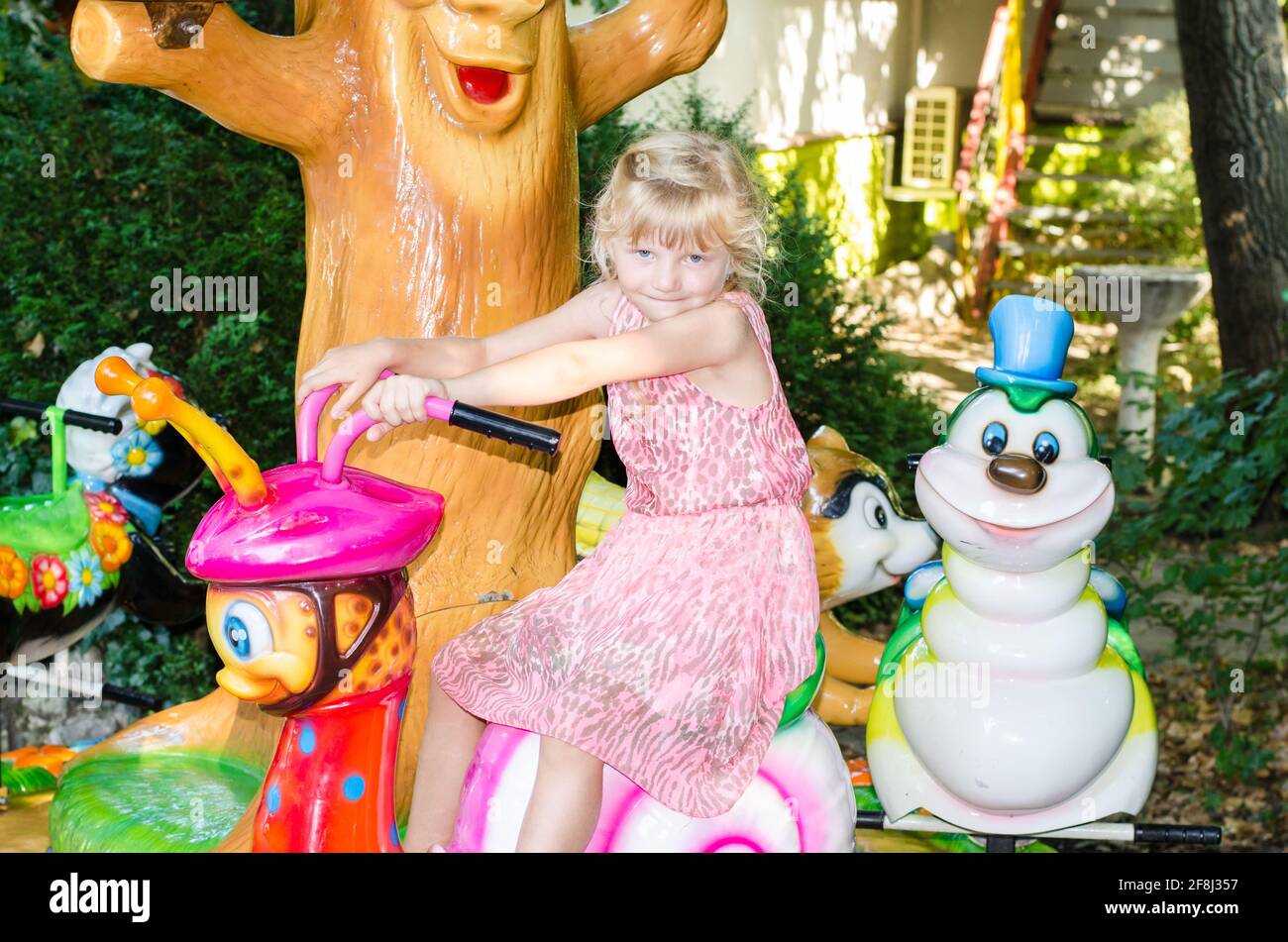petite fille blonde dans l'attraction pour enfants Banque D'Images