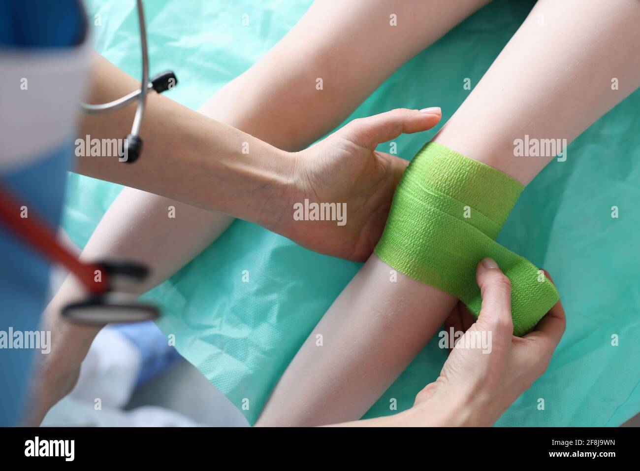 Le médecin met le bandage sur la jambe blessée de l'enfant Banque D'Images