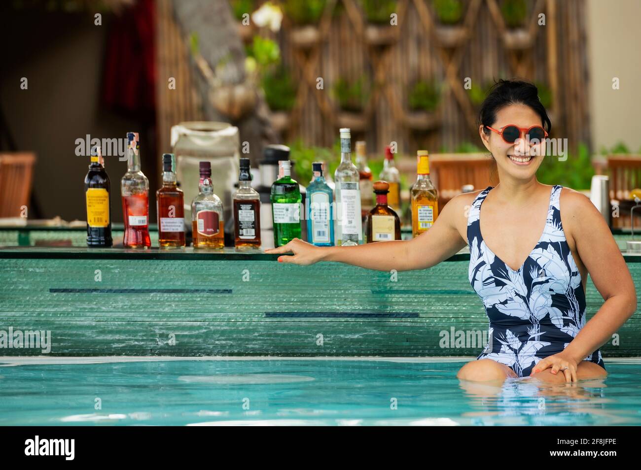 Femme assise au bar de la piscine sur l'île tropicale Koh Phangan Banque D'Images