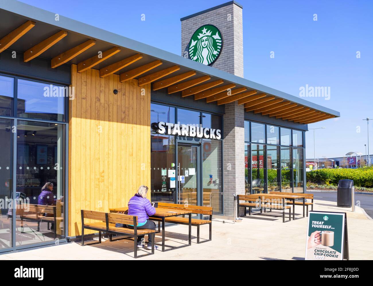 Starbucks café et femme au drive-in assis avec café à emporter Victoria Retail Park Netherfield Nottingham East Midlands Angleterre GB UK Europe Banque D'Images