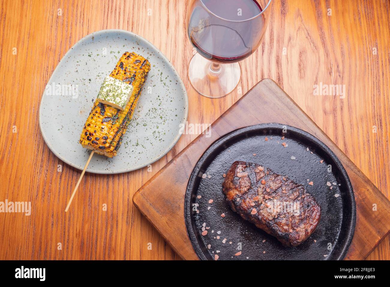 Steak grillé et garniture de maïs jaune sur une table en bois. Cuisine gastronomique. Banque D'Images
