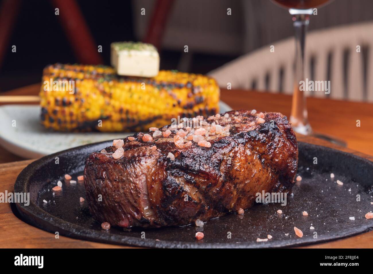 Steak grillé et garniture de maïs jaune sur une table en bois. Cuisine gastronomique. Banque D'Images