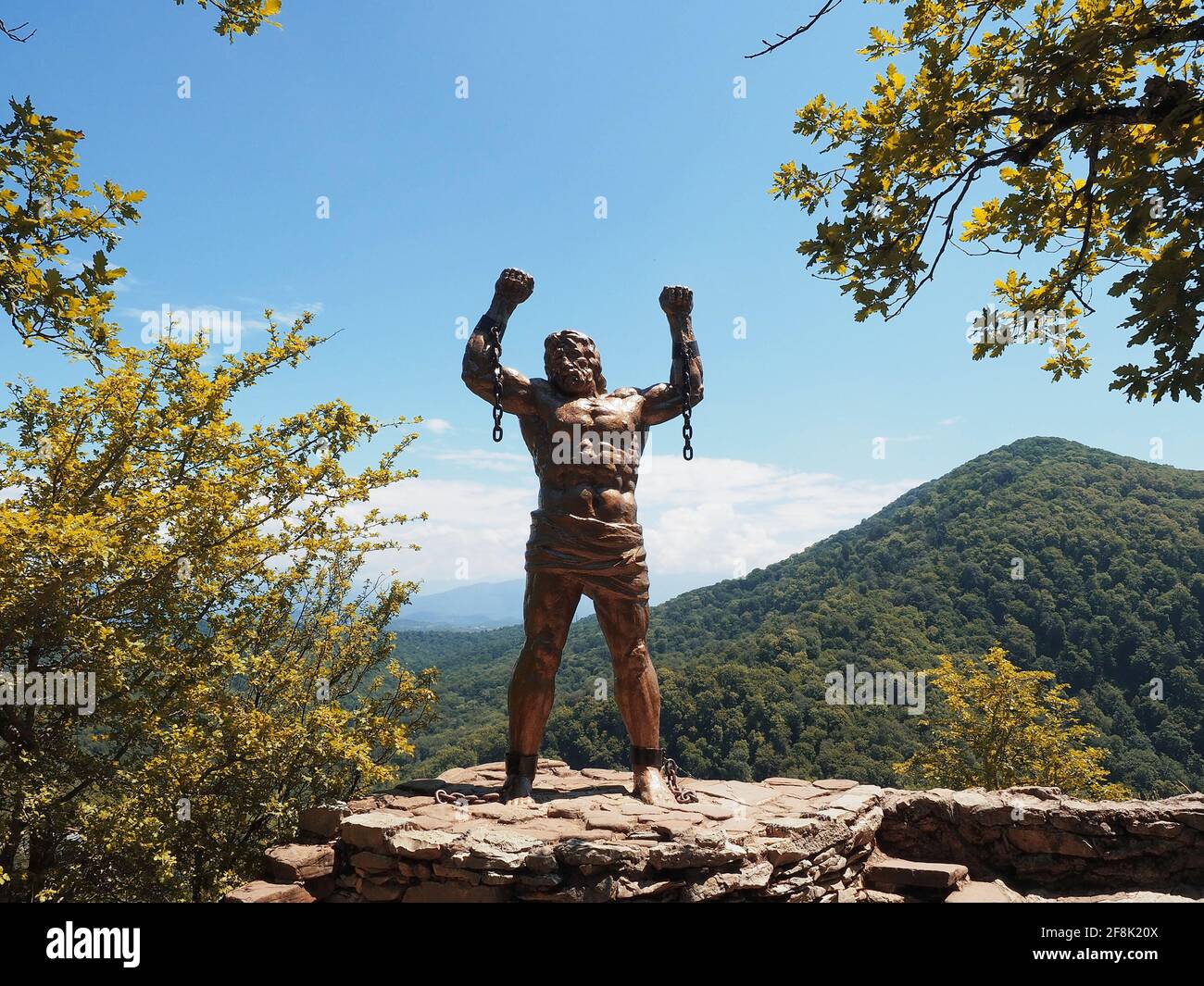 Russie, Sotchi 12.07.2020. La statue de prométhée se dresse sur une colline de pierre, sur fond de montagnes vertes et de ciel bleu Banque D'Images