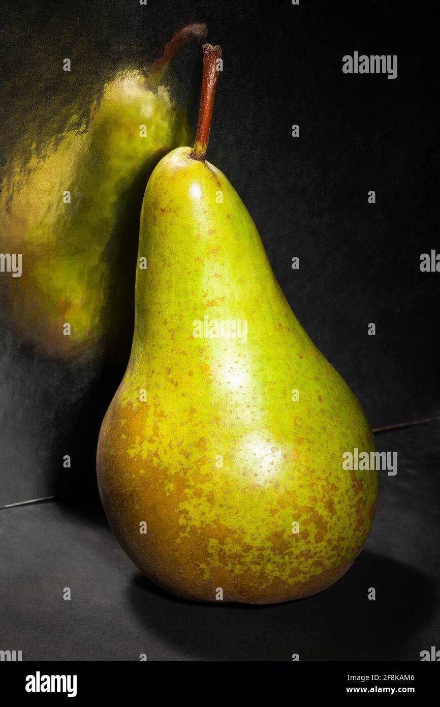 poire verte symétrique sur fond noir Banque D'Images