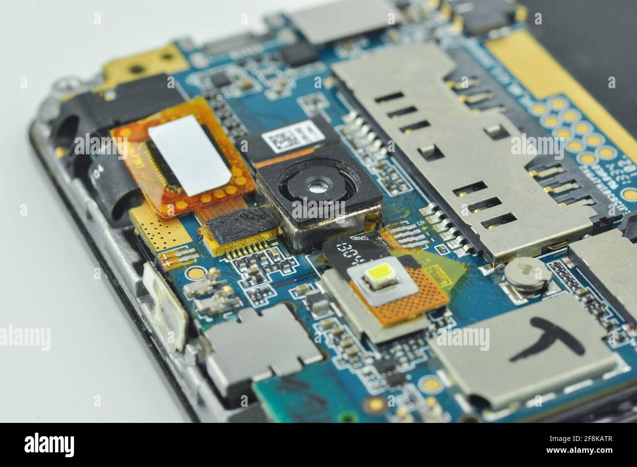 Téléphone mobile ou smartphone démonté. Carte de circuit imprimé, caméra, microcircuit, logements pour cartes sim. Photo macro. Banque D'Images
