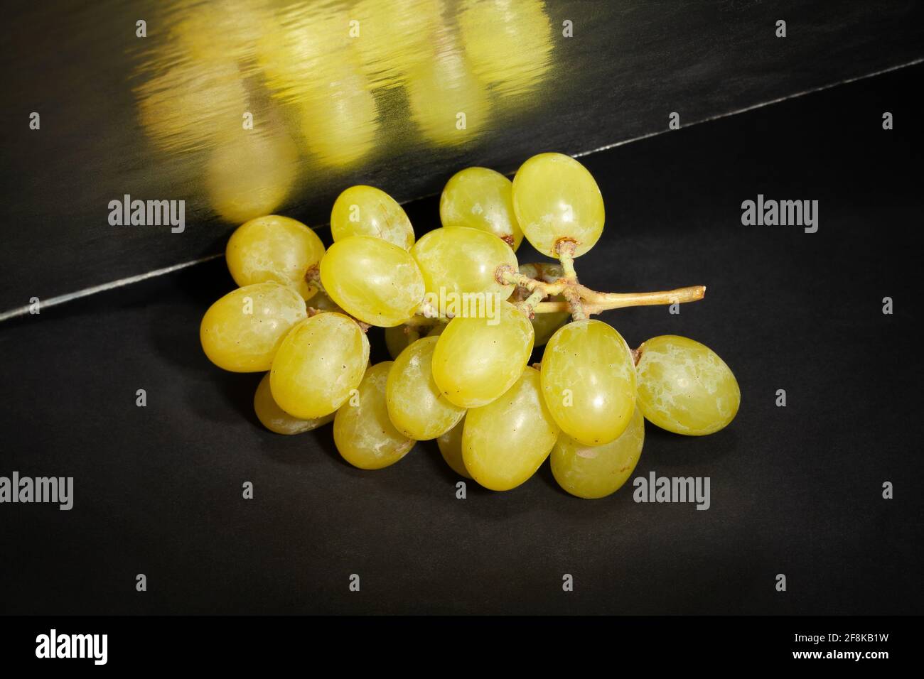 raisin blanc miroir sur fond noir Banque D'Images