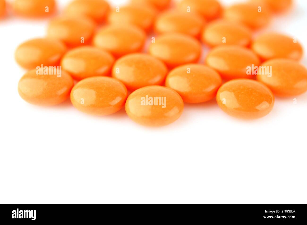 Pilules orange sur fond blanc. Mise au point sélective. Banque D'Images