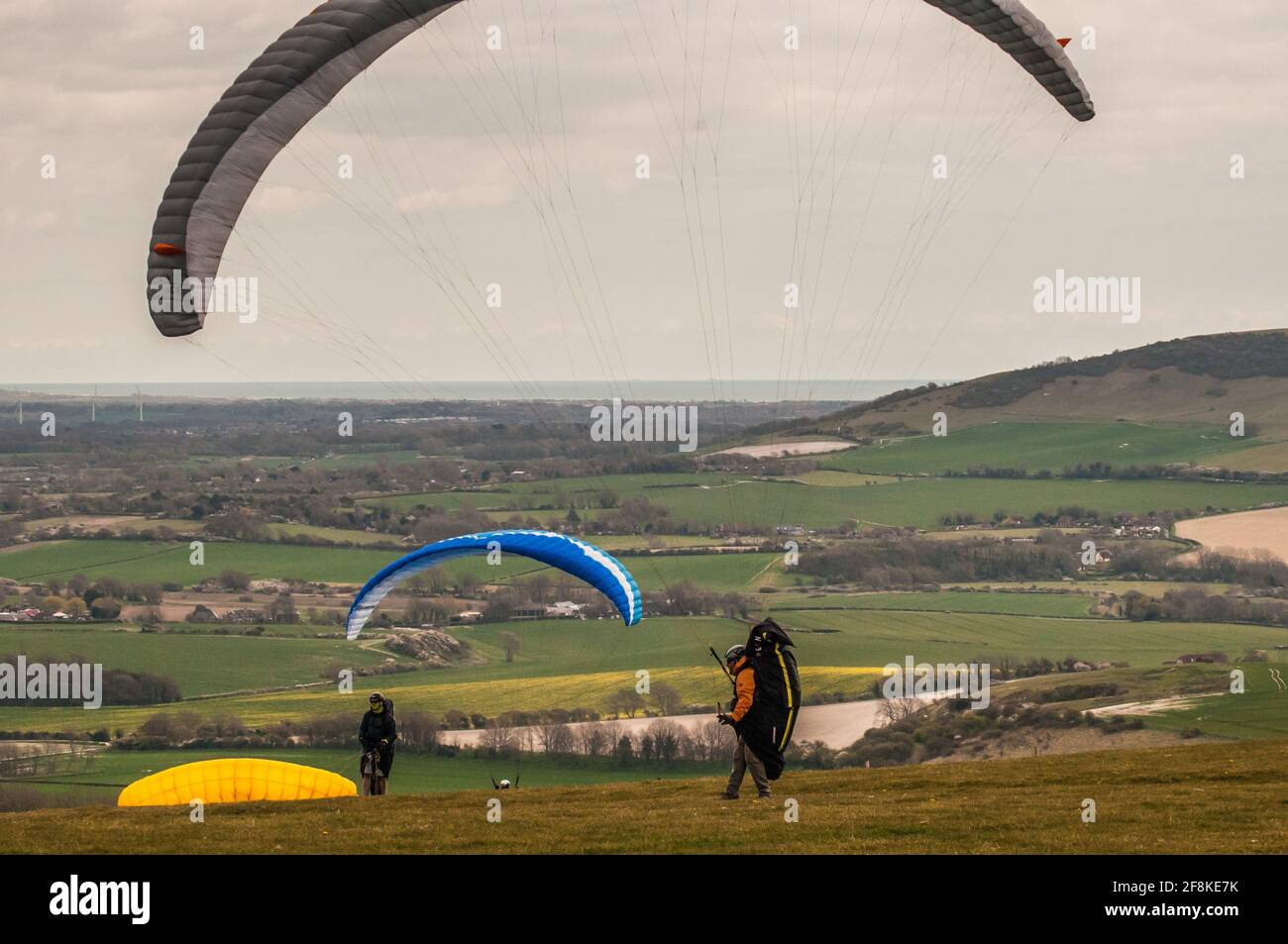 Bo PEEP, Alciston, Lewes, East Sussex, Royaume-Uni. 14 avril 2021. Un bon début de journée avec l'augmentation du nuage dans l'après-midi. Le vent froid du Nord-est amène les pilotes de parapente à PEEP Bo sur la voie des Southlovers, au-dessus de la magnifique campagne du Sussex. Crédit : David Burr/Alay Live News Banque D'Images