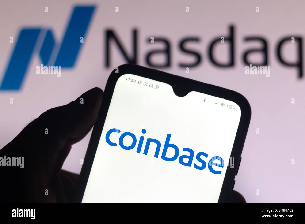 Dans cette illustration, le logo Coinbase affiché sur l'écran d'un smartphone avec le logo de Nasdaq en arrière-plan. Banque D'Images