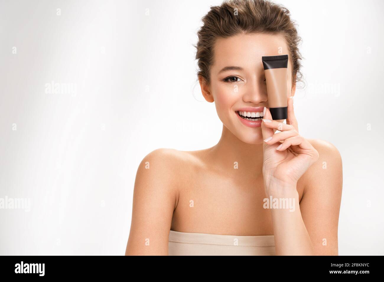 Femme avec une fondation liquide. Photo de femme avec maquillage parfait sur fond blanc. Concept de beauté Banque D'Images