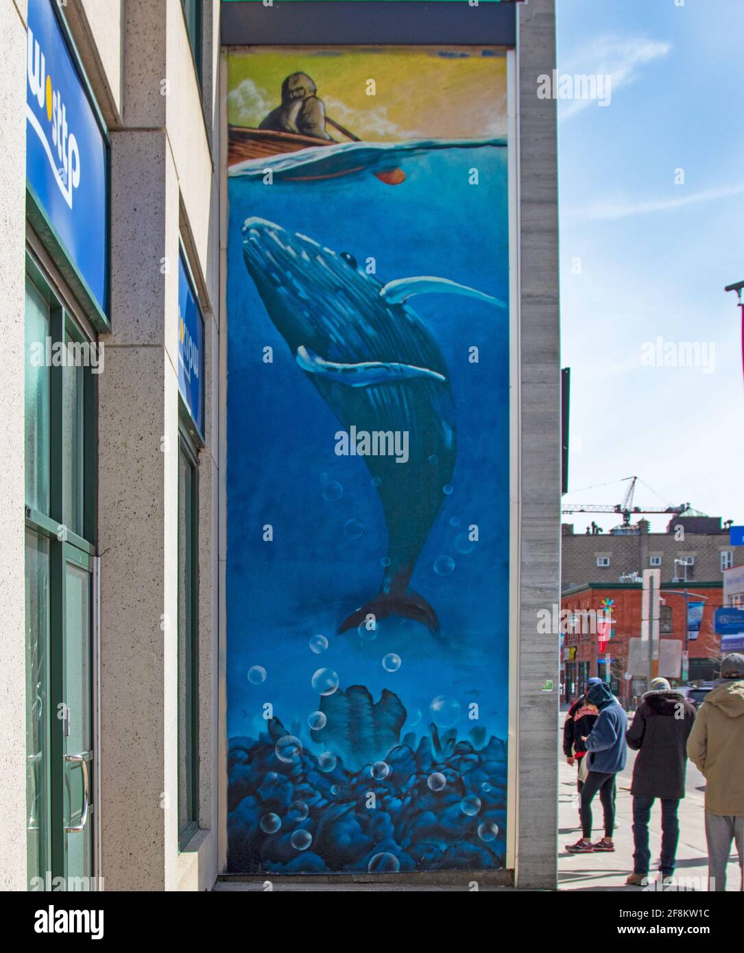 Un ciel bleu et une fresque de baleine lumineuse à côté de laquelle les gens attendez dans la ligne à 6 pieds l'un de l'autre pour leur tour à achat (légal) pot Banque D'Images