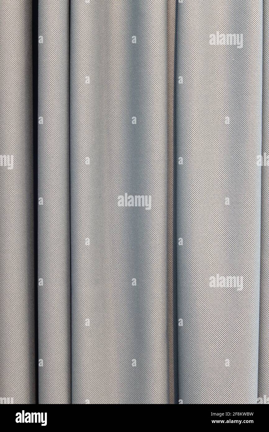 Rideaux gris en tissu naturel soyeux, avec grands plis, gros plan. Détails de concept d'un intérieur moderne et élégant, l'utilisation de matériaux naturels dans Banque D'Images