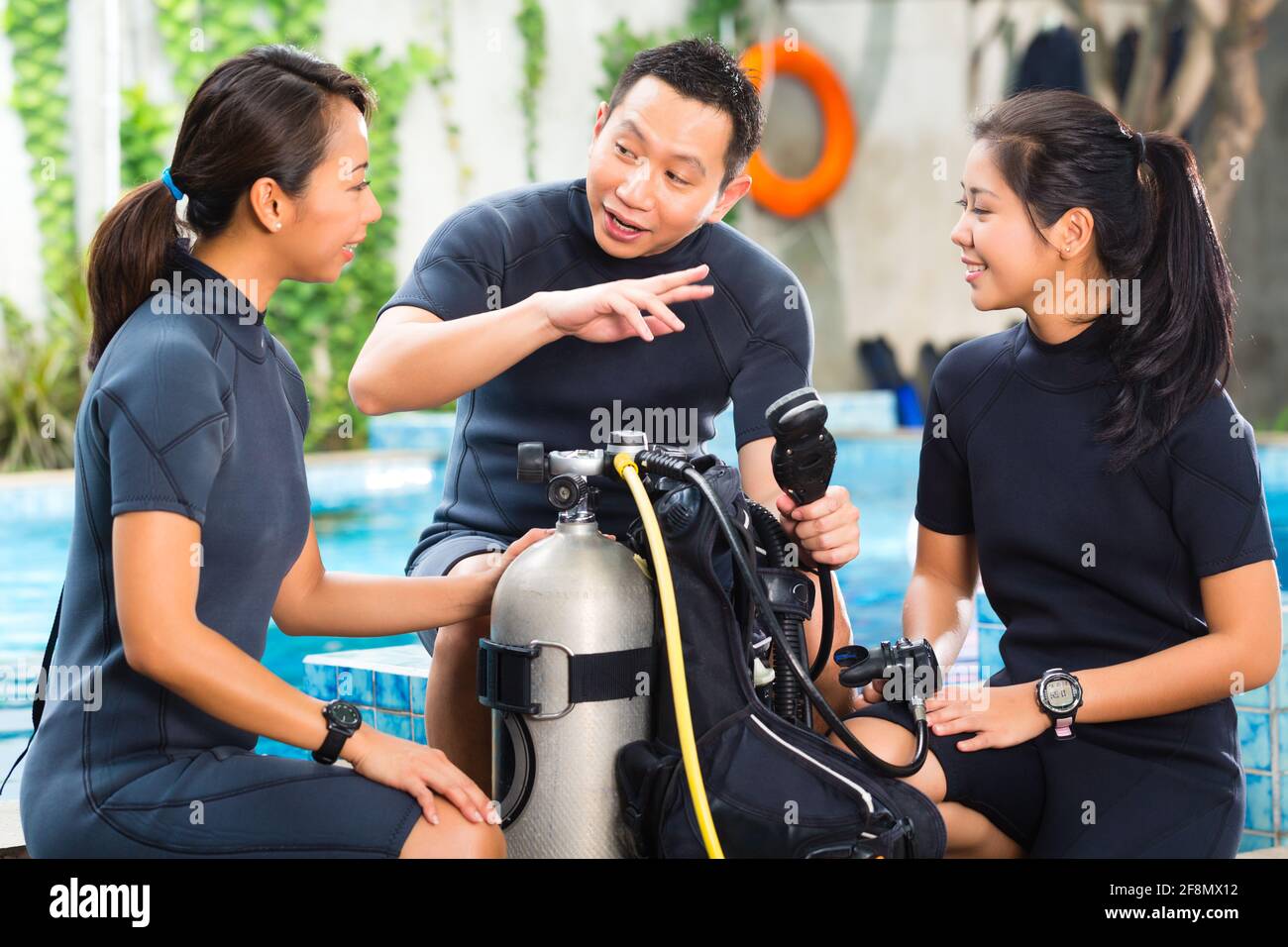 Les gens d'Asie à la diver en école de plongée en combinaison avec un réservoir d'oxygène Banque D'Images