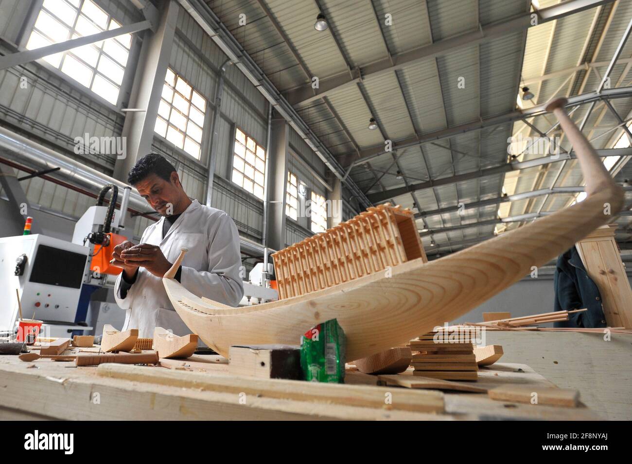 13 avril 2021, Egypte, Ojour ville: Un artisan travaille sur la création d'un modèle miniature de l'ancien navire égyptien Khufu, à l'usine de Konouz, la première usine de la région pour les reproductions archéologiques. Les clones antiques sont d'abord disponibles à l'achat au Musée des civilisations égyptiennes du Caire (NMEC) et seront distribués sur demande aux musées et aux boutiques touristiques du monde entier. Chaque pièce produite par l'usine portera un cachet officiel du Conseil suprême des Antiquités d'Égypte et un code à barres fournissant des informations sur la pièce originale, comme le nom, le lieu d'exposition et la mère Banque D'Images