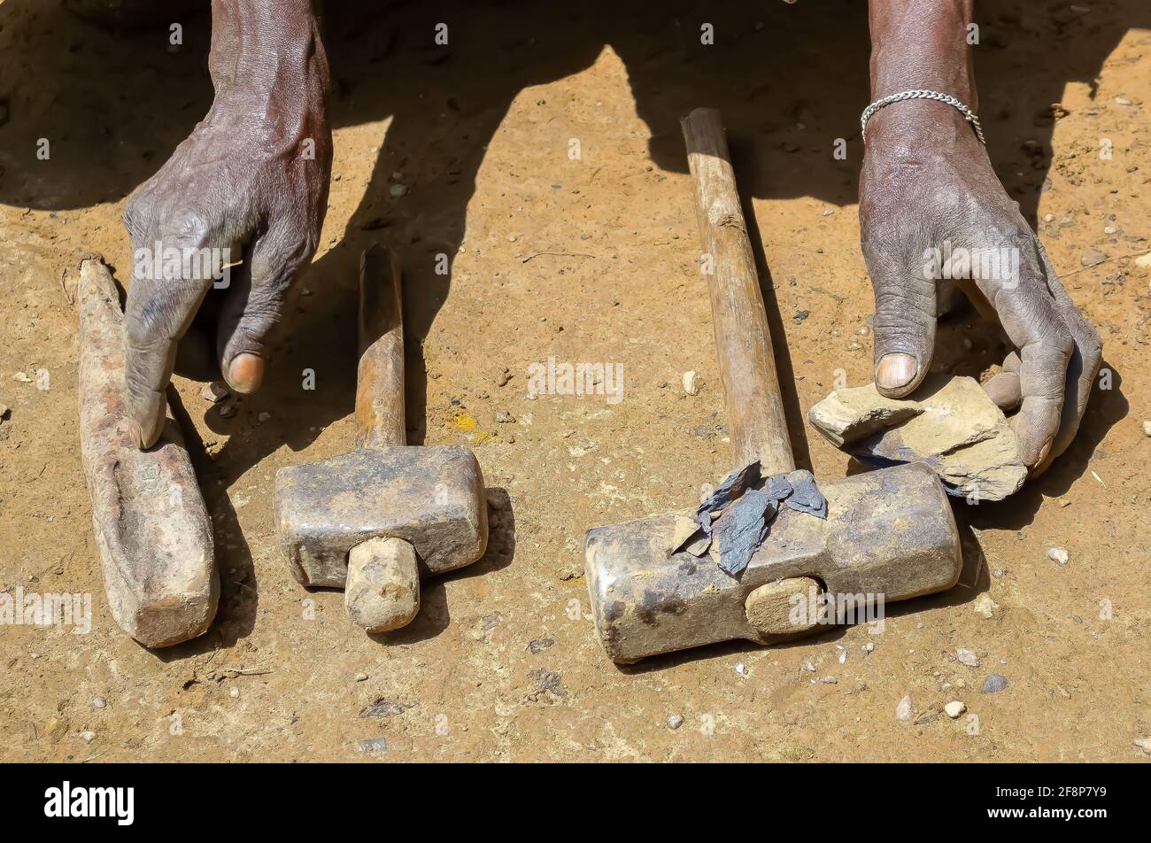 Le temps de rembobinage en Ouganda : l'air des soufflets en peau de mouton dans un four au charbon de bois, le forgeron s'accroche au métal chaud rouge et le fait buer dans des outils Banque D'Images