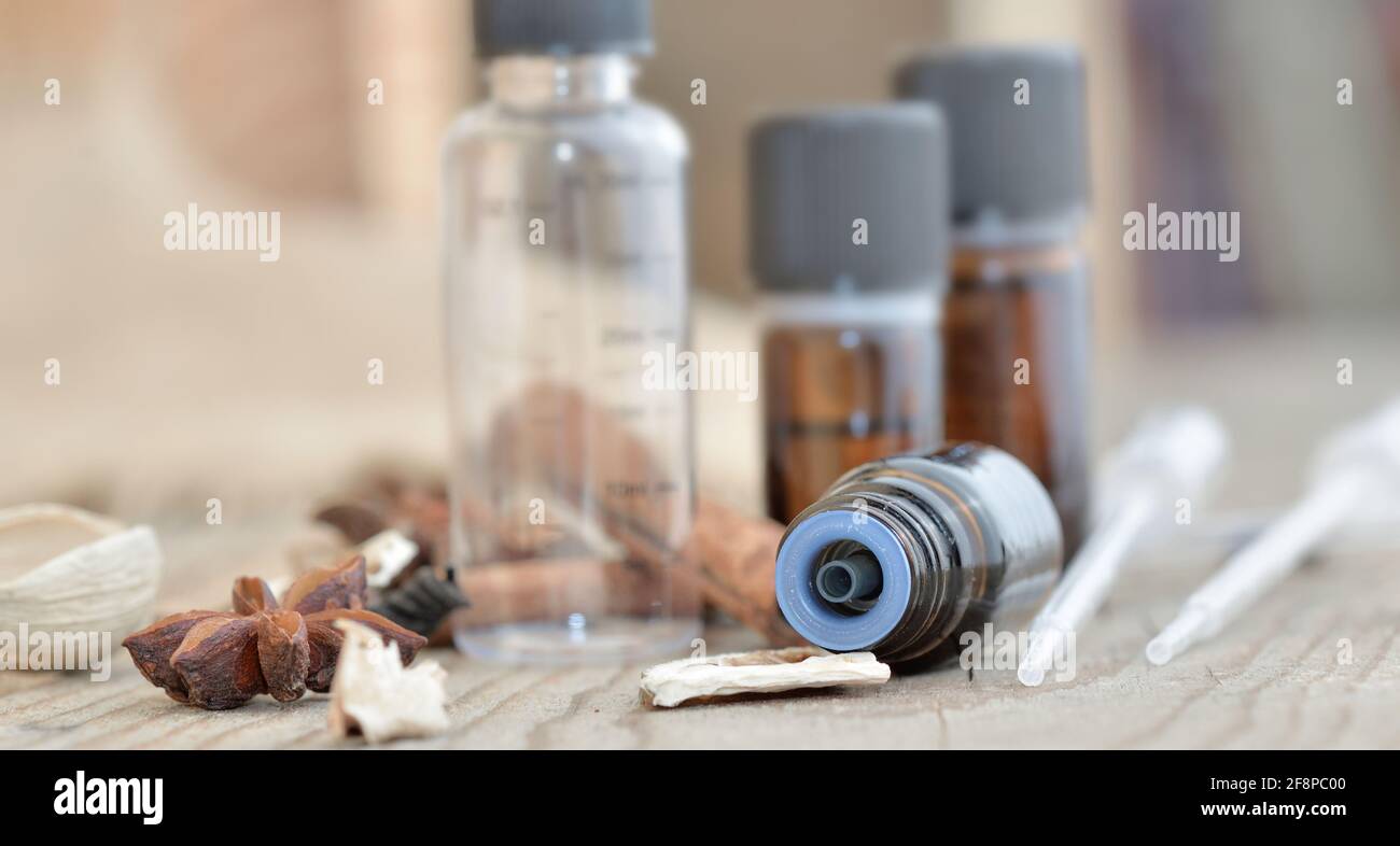 bouteilles d'huile essentielle et d'épices sur une table en bois avec pipette pour extraire l'essence Banque D'Images