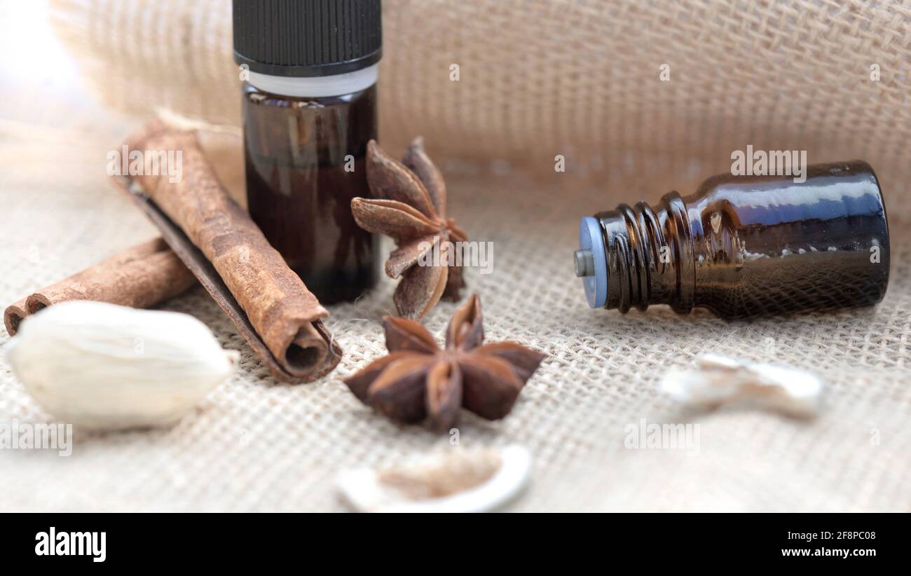 bouteilles d'huile essentielle et bâton de cannelle et de badian sur un fond en tissu naturel Banque D'Images