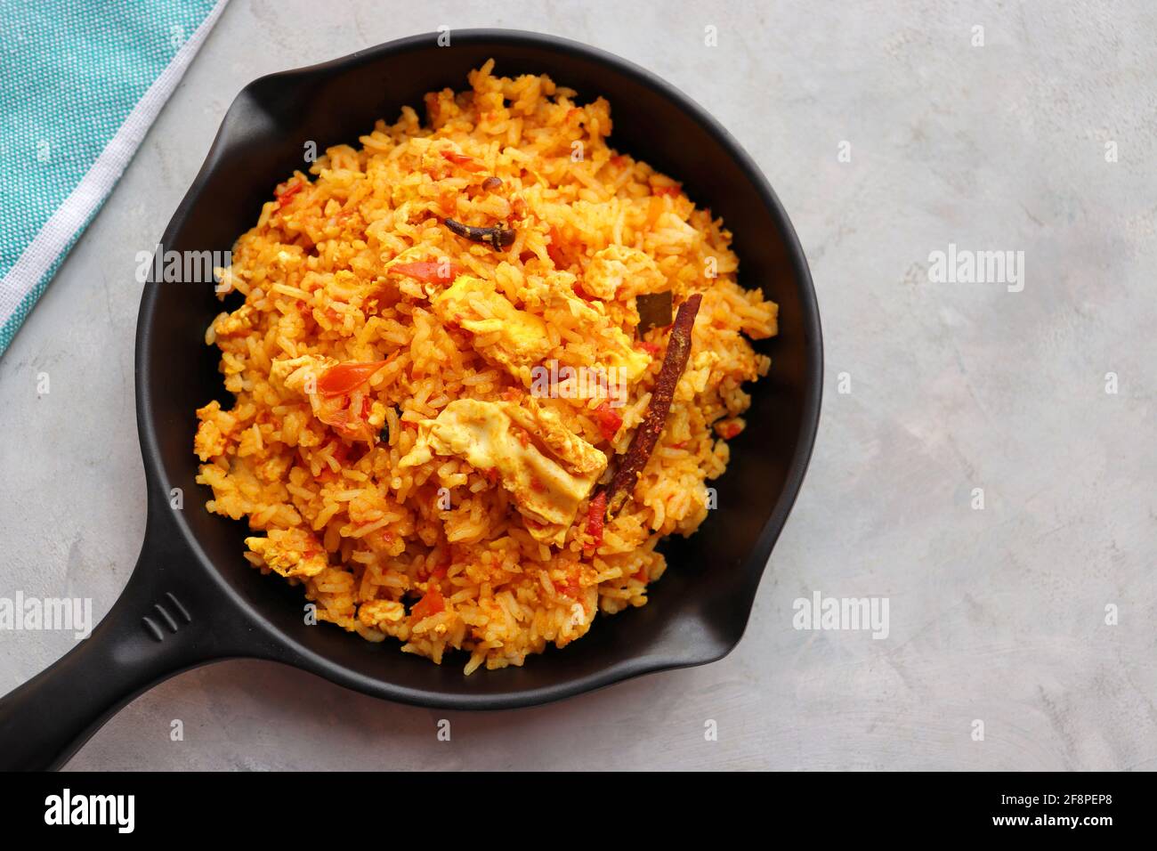 Riz aux tomates avec œufs. Incorporer le riz frit dans la sauce tomate épicée, mélangé avec des œufs et des épices. Servi dans une poêle à repasser. Banque D'Images