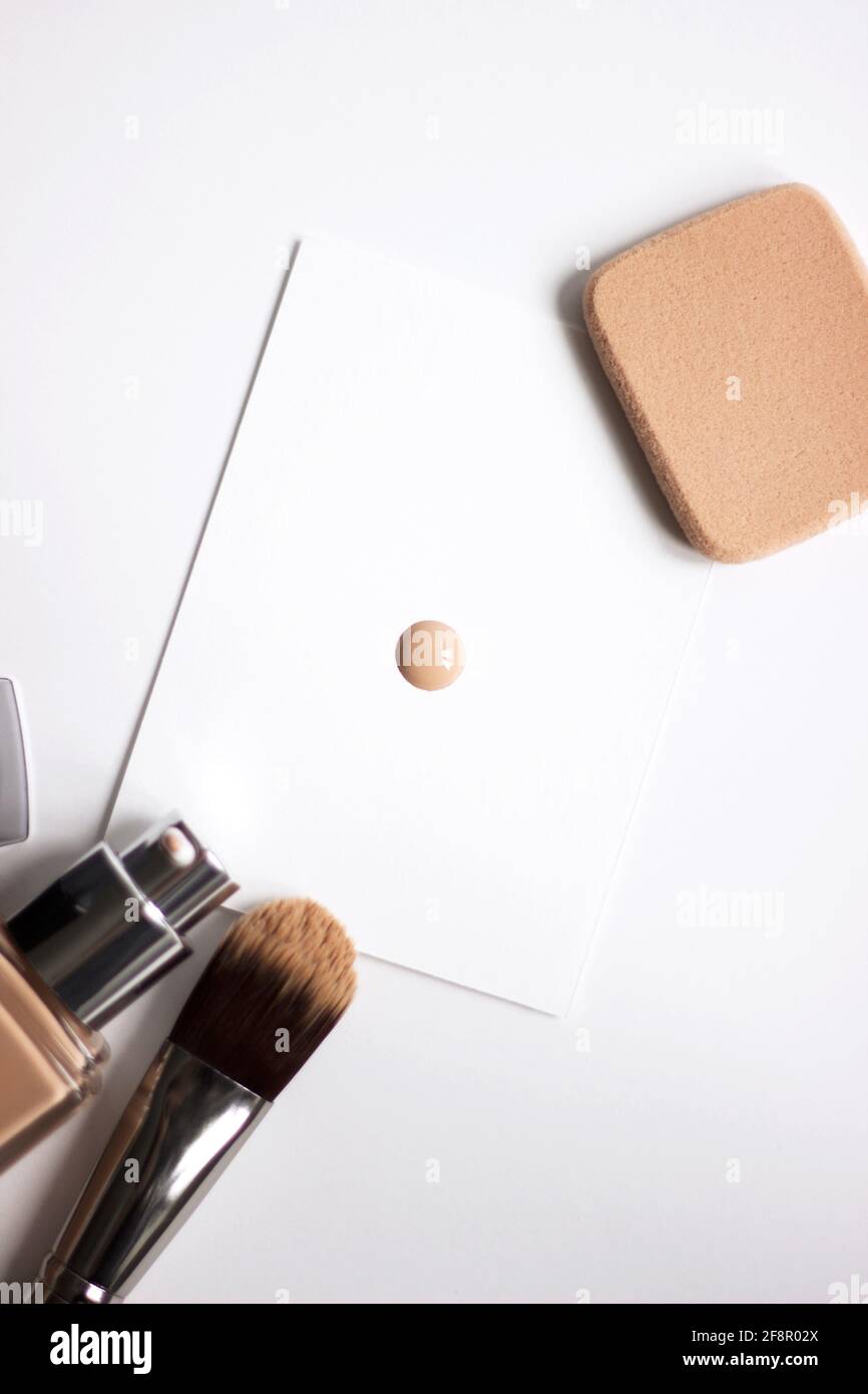 Cosmétiques de maquillage. Fond de teint avec brosse et éponge. Ensemble de produits pour le visage tendance isolé sur fond blanc. Banque D'Images