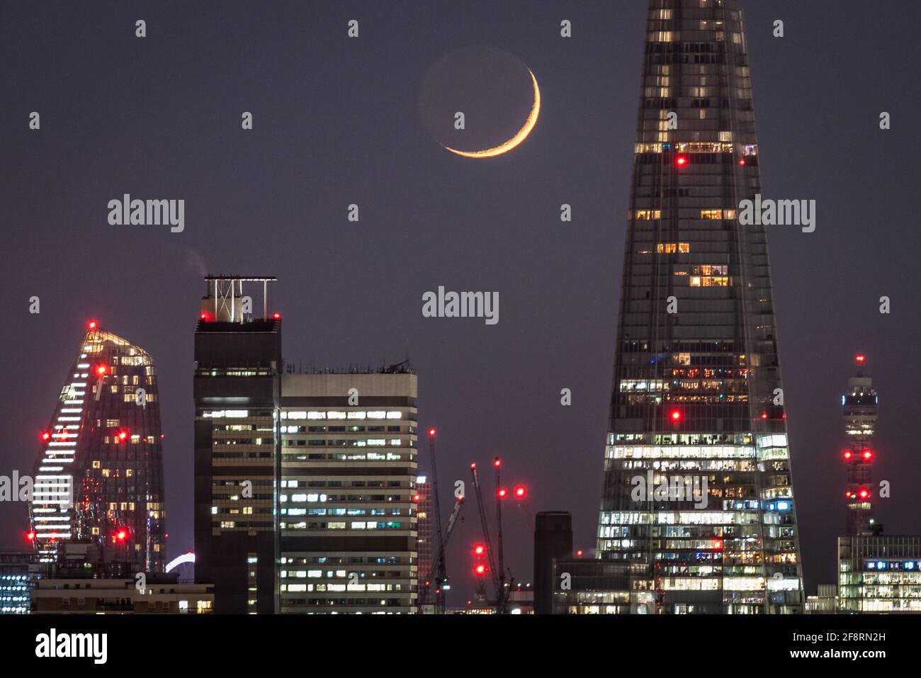 Londres, Royaume-Uni. 14 avril 2021. Météo au Royaume-Uni : une lune de Crescent qui se dresse à la fin du mercredi, passant devant le gratte-ciel de Shard en suivant une direction nord-ouest. Credit: Guy Corbishley/Alamy Live News Banque D'Images