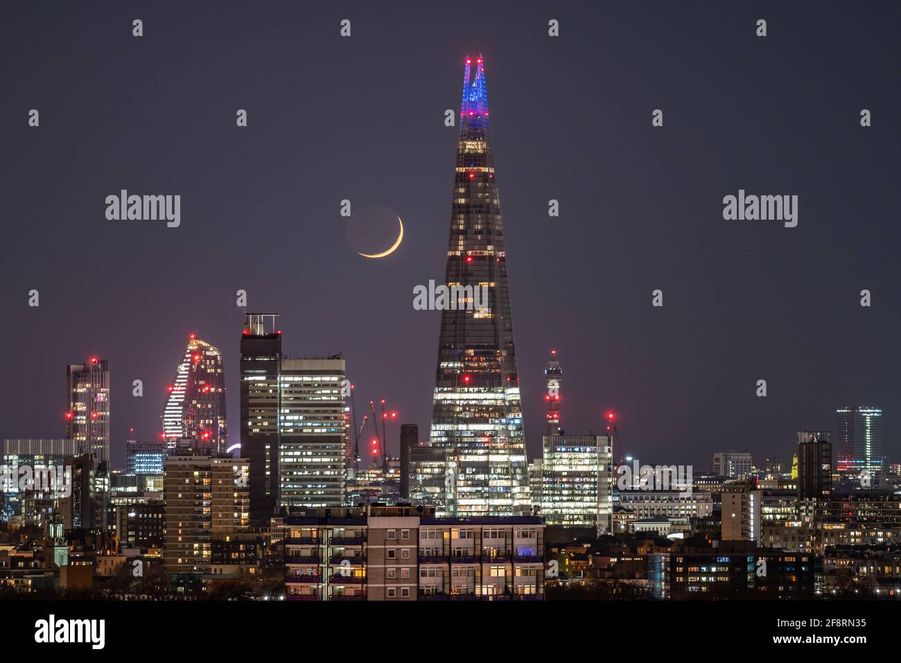 Londres, Royaume-Uni. 14 avril 2021. Météo au Royaume-Uni : une lune de Crescent qui se dresse à la fin du mercredi, passant devant le gratte-ciel de Shard en suivant une direction nord-ouest. Credit: Guy Corbishley/Alamy Live News Banque D'Images