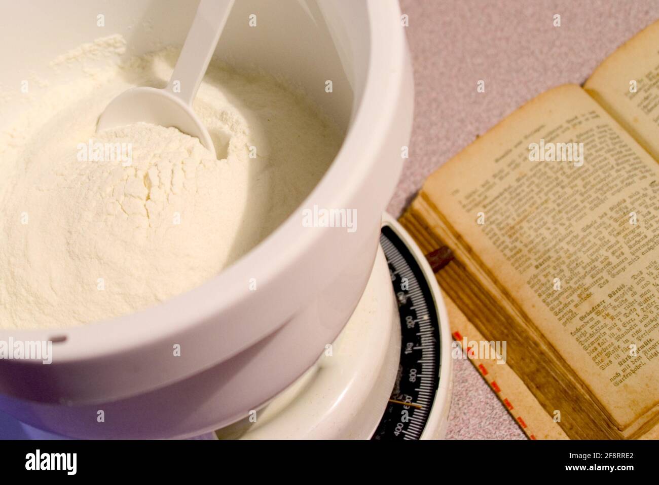 vieux livre de pâtisserie avec balance de cuisine pleine de farine Banque D'Images