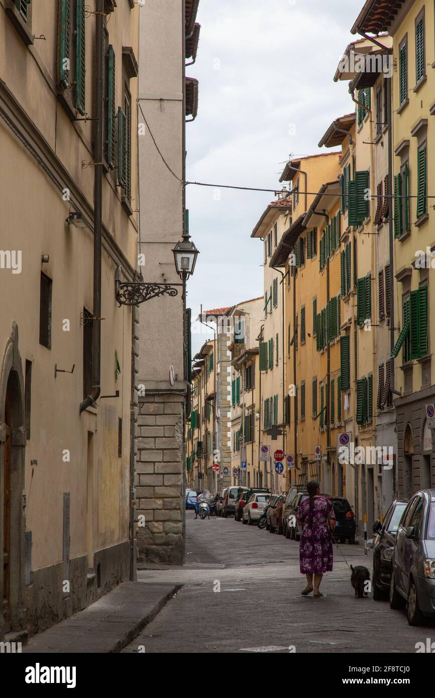 Une femme locale marche chien sur la rue arrière de Florence, Italie Banque D'Images