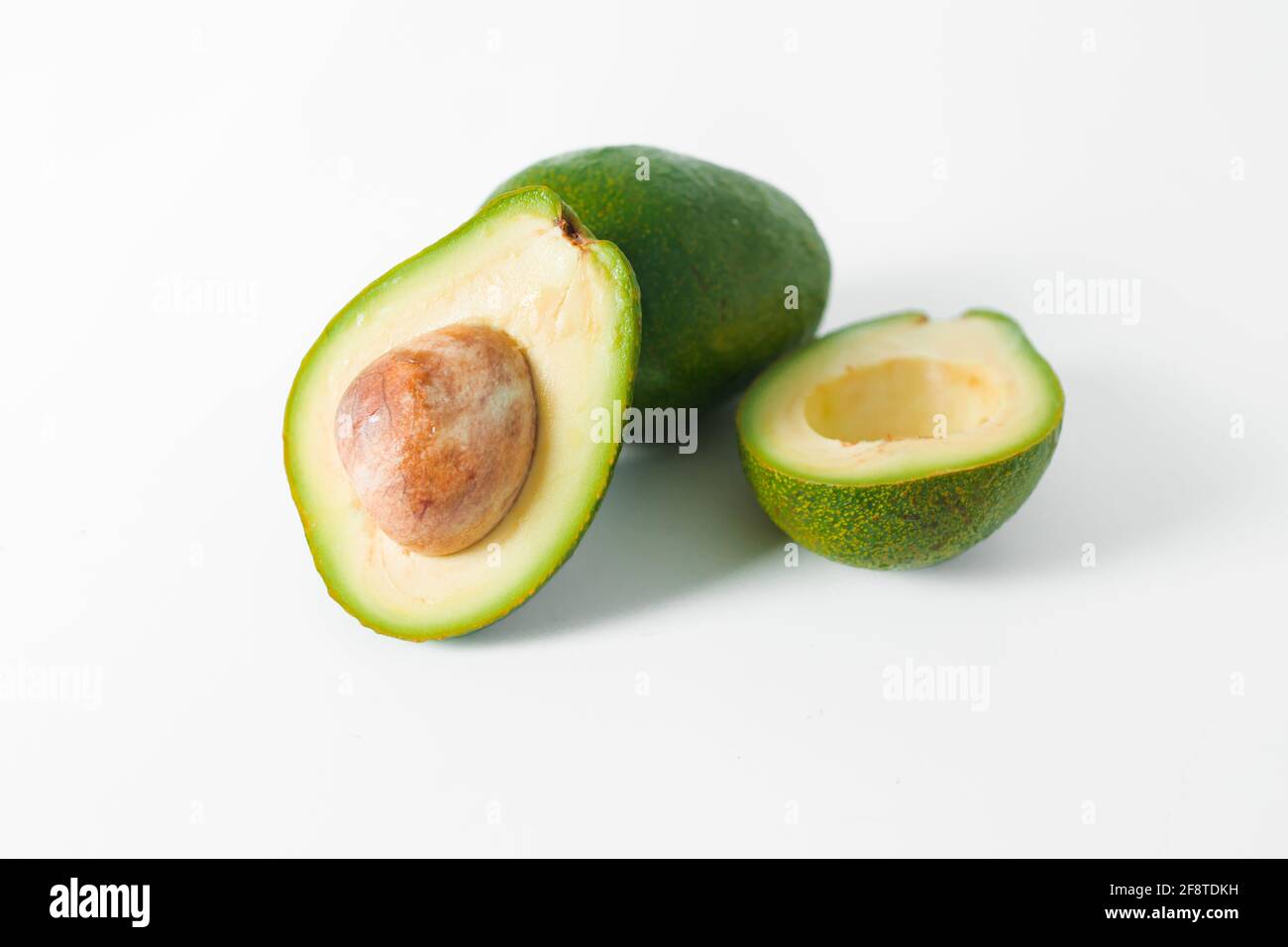 Fruit d'avocat entier et moitié sur fond blanc. Concept de nourriture naturelle. Banque D'Images