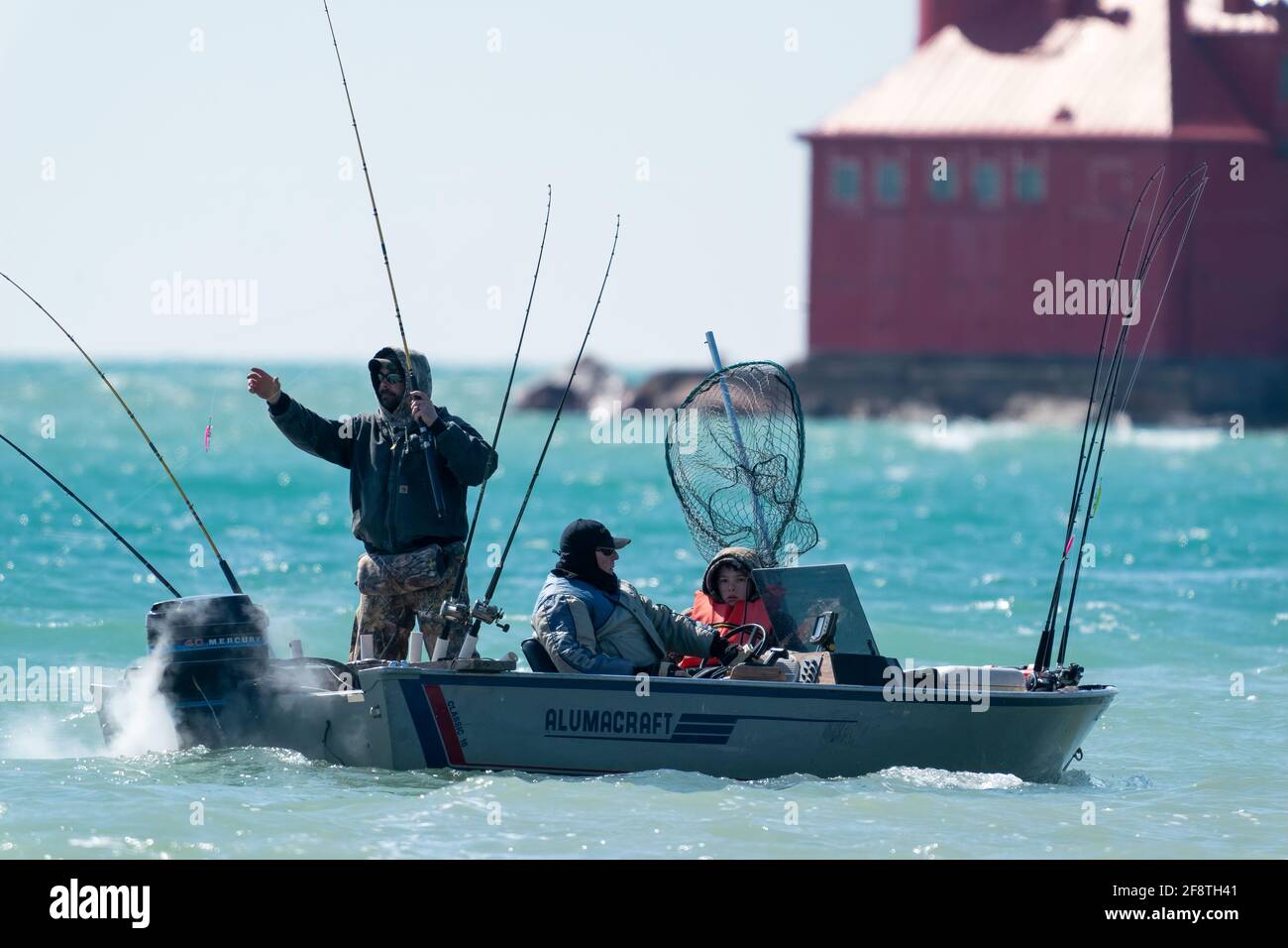 Les pêcheurs intrépides bravent le vent et le temps froid pour pêcher en début de saison près du brise-lames du canal de navigation de Sturgeon Bay, Wisconsin. Banque D'Images