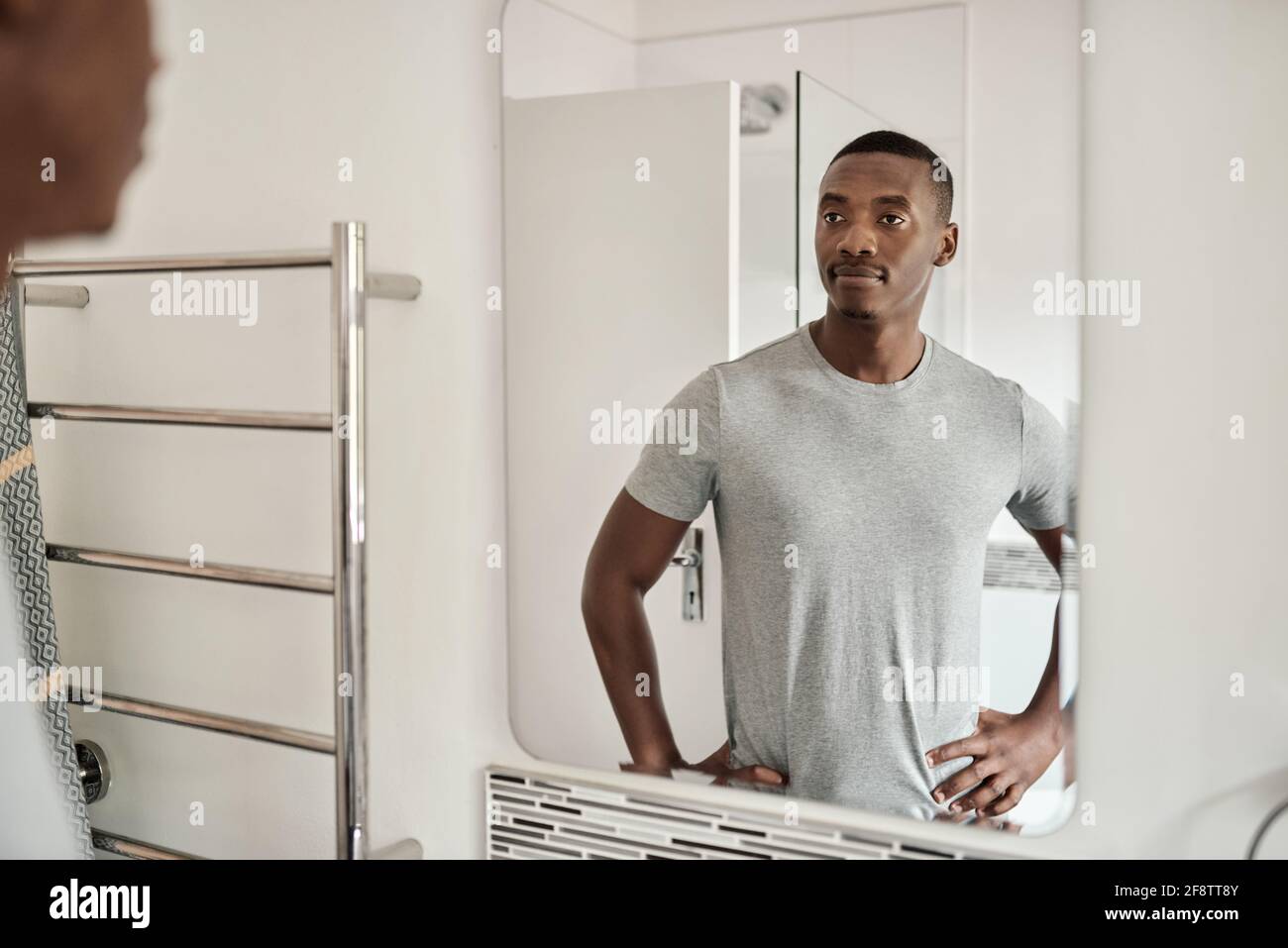 Jeune Africain debout dans sa salle de bain le matin Banque D'Images