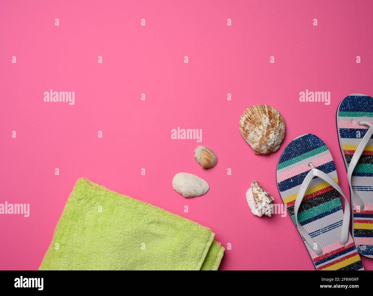 pantoufles multicolores pour femmes et seashell sur fond rose, vue du dessus Banque D'Images