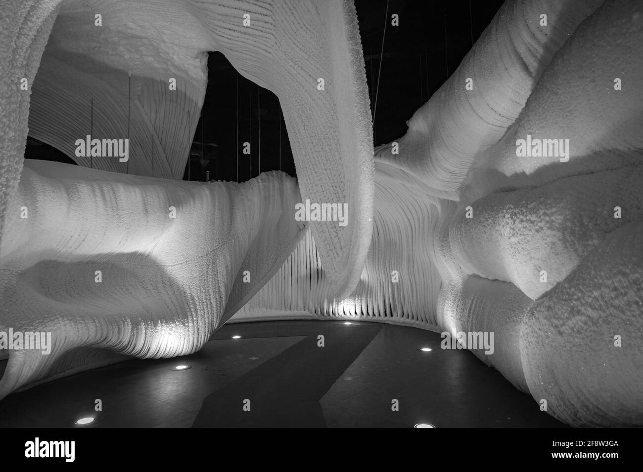 Une fabuleuse grotte de glace artificielle, les murs sont couverts de neige et illuminés. Glace congelée et froide à l'intérieur Banque D'Images