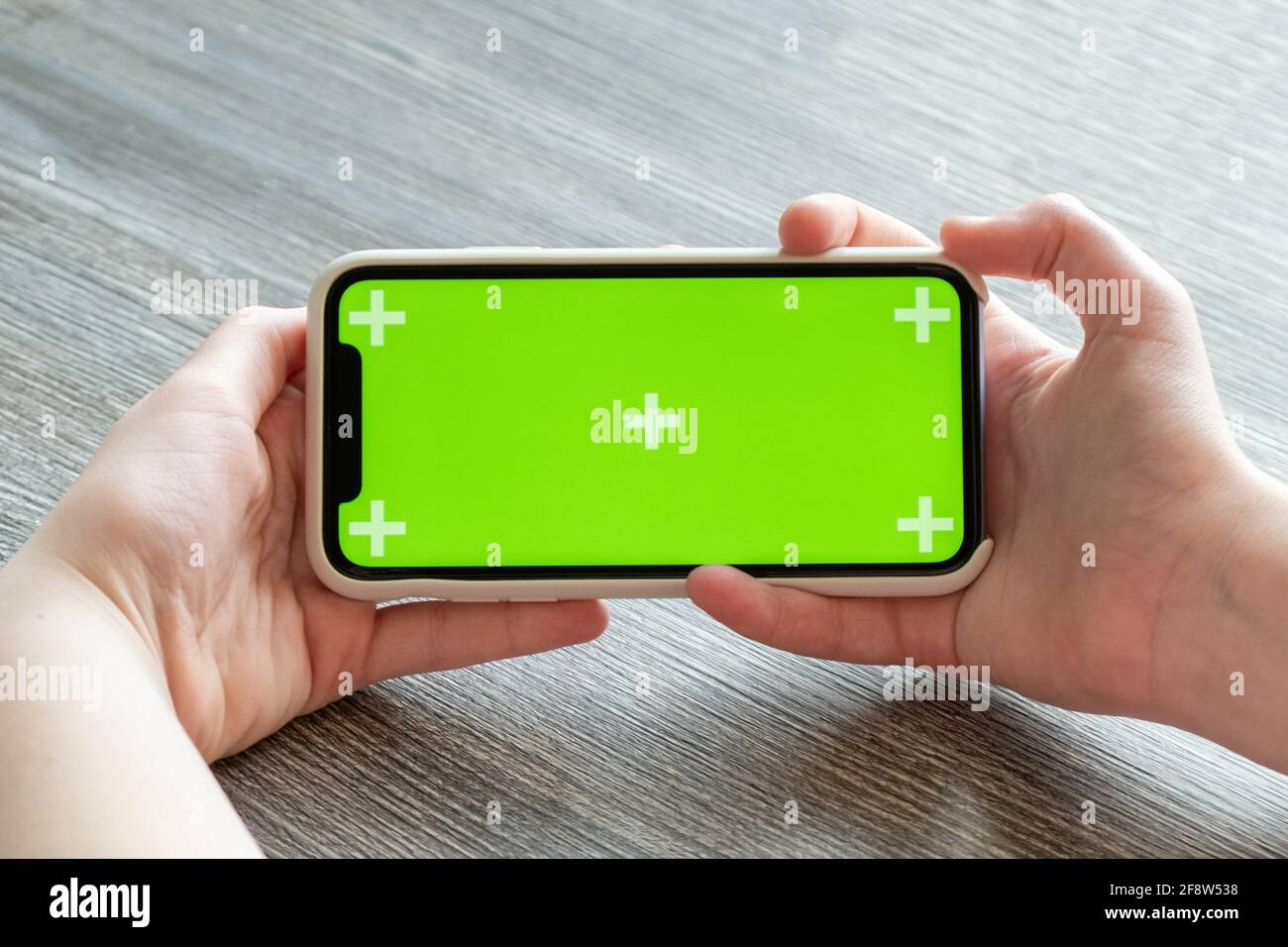 Smartphone avec écran vert entre les mains. Gros plan - image Banque D'Images