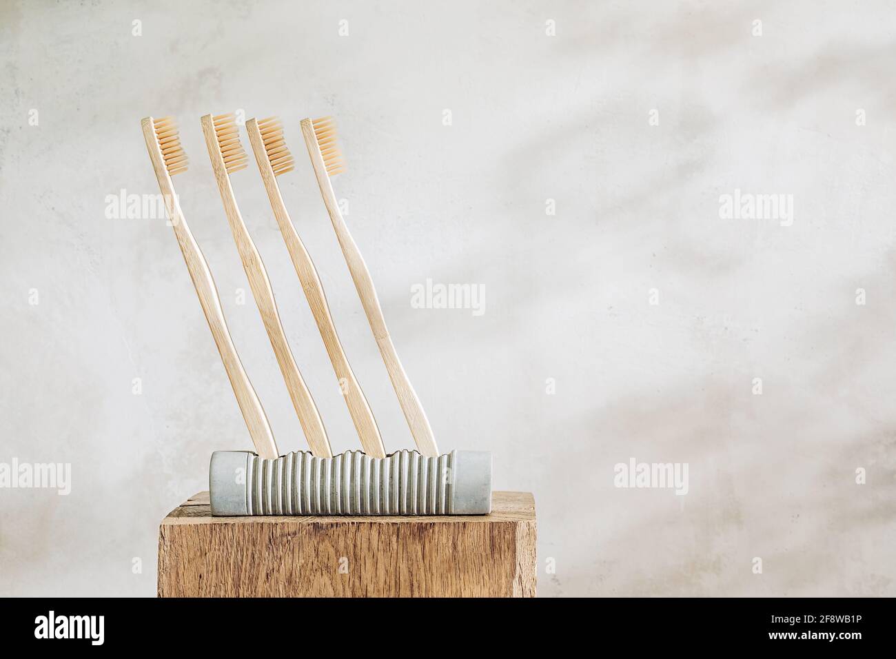 Brosses à dents en bois sur un support en béton. Matériaux naturels et couleurs chaudes. Concept écologique Banque D'Images